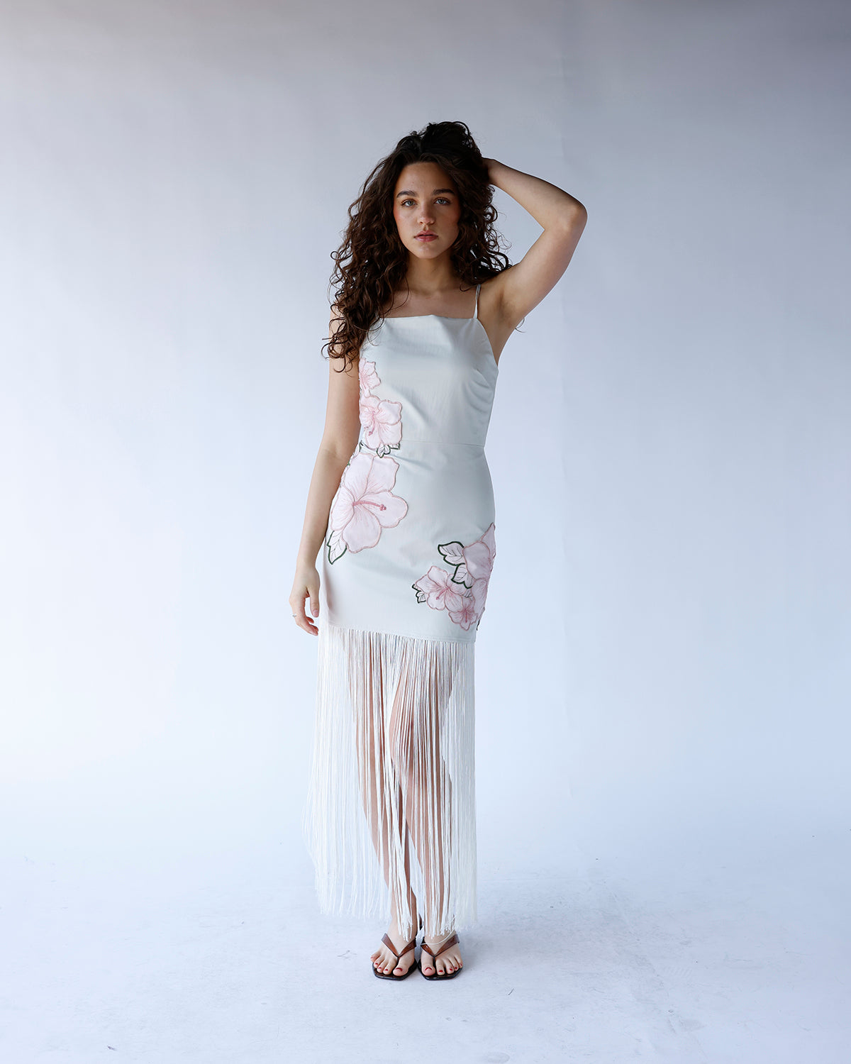white maxi dress with floral print and fringe hem