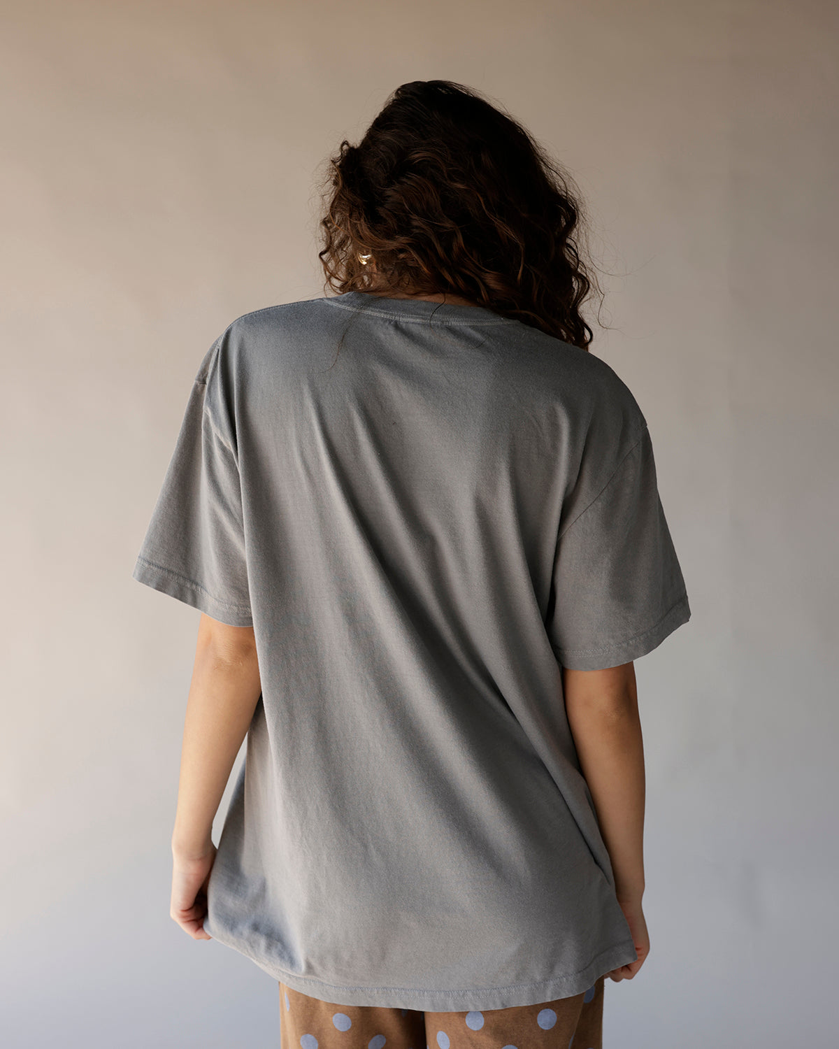 Oversized gray graphic tee shown from back, relaxed fit, short sleeves