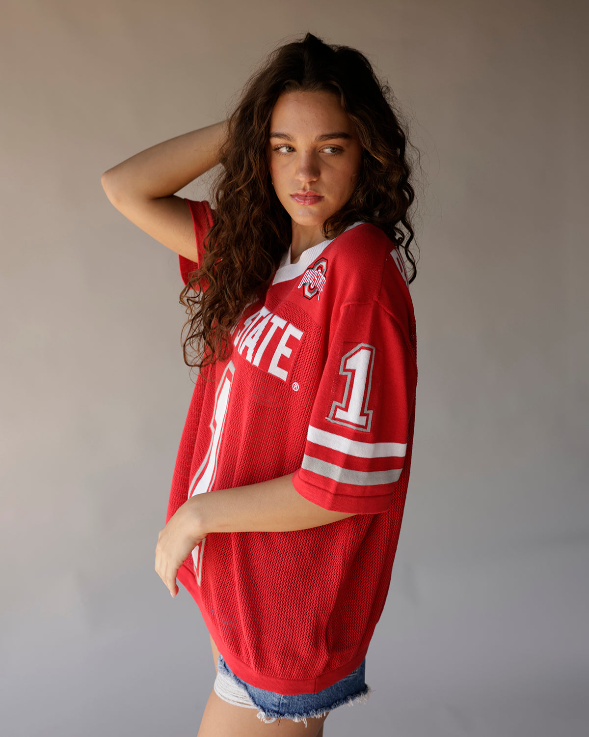 Women's oversized red Ohio State football jersey with white stripes and denim shorts