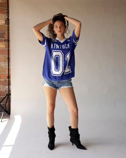 Blue Kentucky Wildcats football jersey number 01 styled with denim shorts and black boots