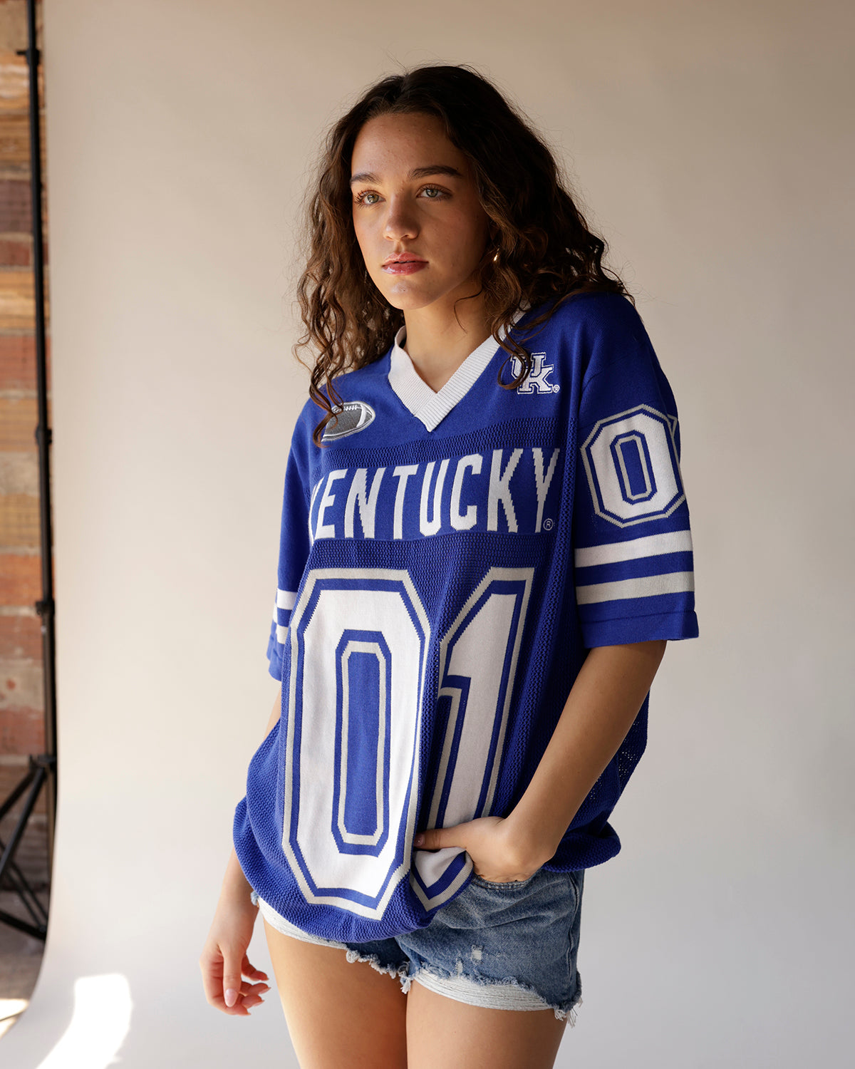Women's blue Kentucky Wildcats football jersey number 01 with denim shorts