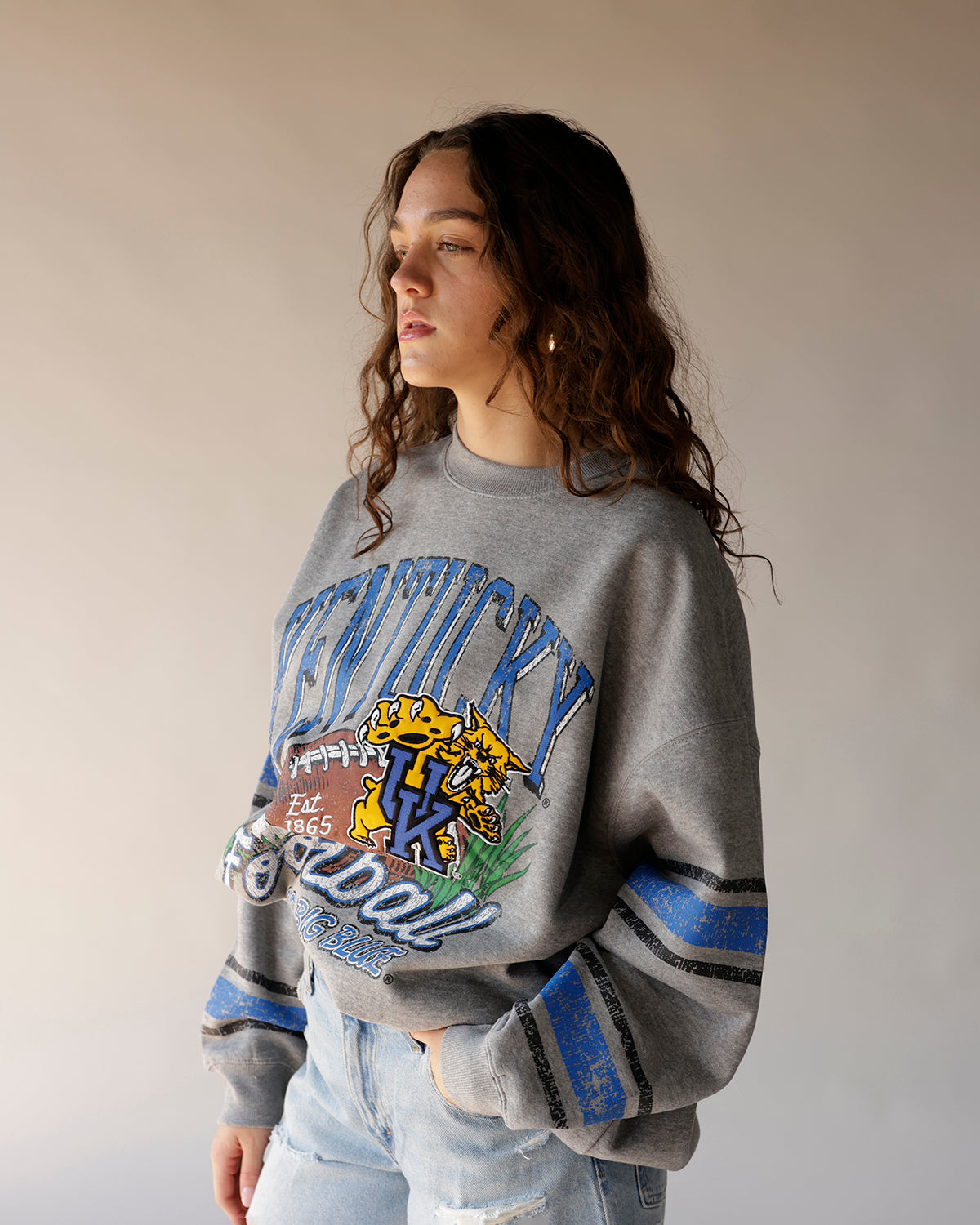 Gray Kentucky Wildcats football crewneck sweatshirt with blue stripes on sleeves