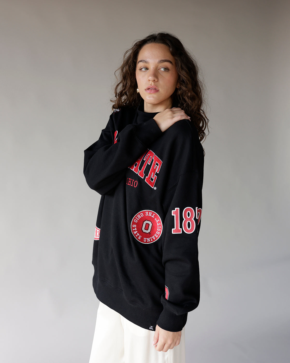Black oversized crewneck sweatshirt with red Ohio State University graphic patches and lettering