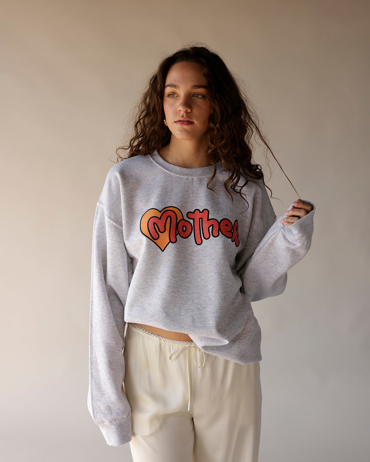 Heather gray oversized crewneck sweatshirt with retro heart graphic and script lettering