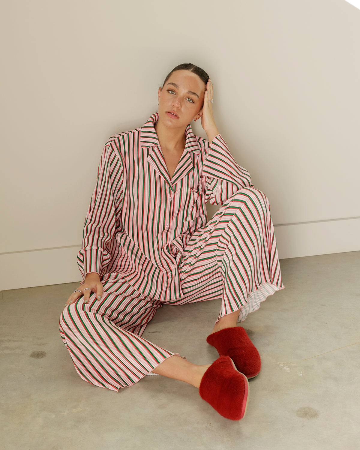 peach love two-piece christmas pajama set featuring pink, red, green and white vertical stripes, a button-down collared top and matching wide-leg pants.