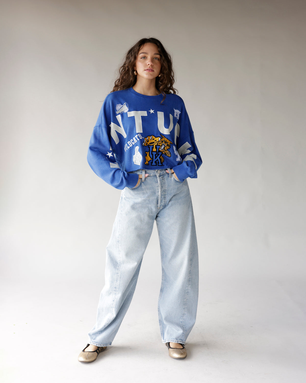 Oversized blue Kentucky Wildcats crop sweatshirt with graphic print, worn with wide-leg jeans