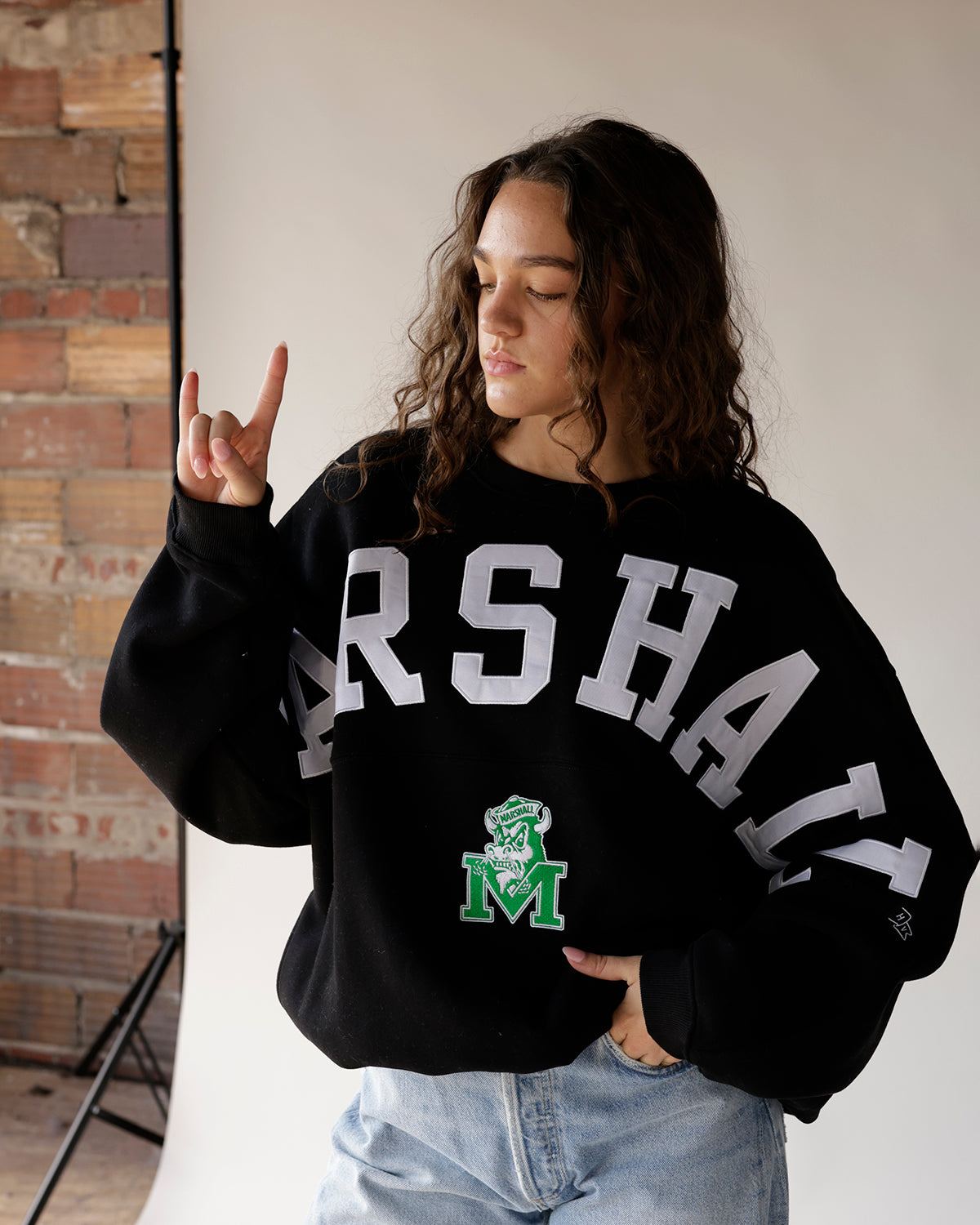 Black Marshall varsity crewneck sweatshirt with white lettering and green mascot logo