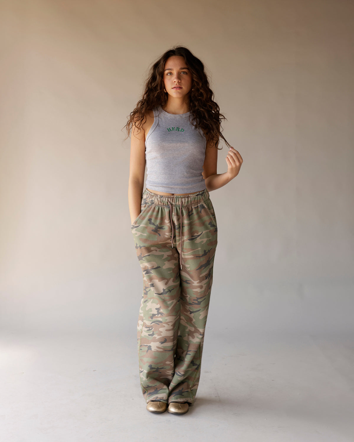 Gray sleeveless racerback crop tank top with green arched text graphic