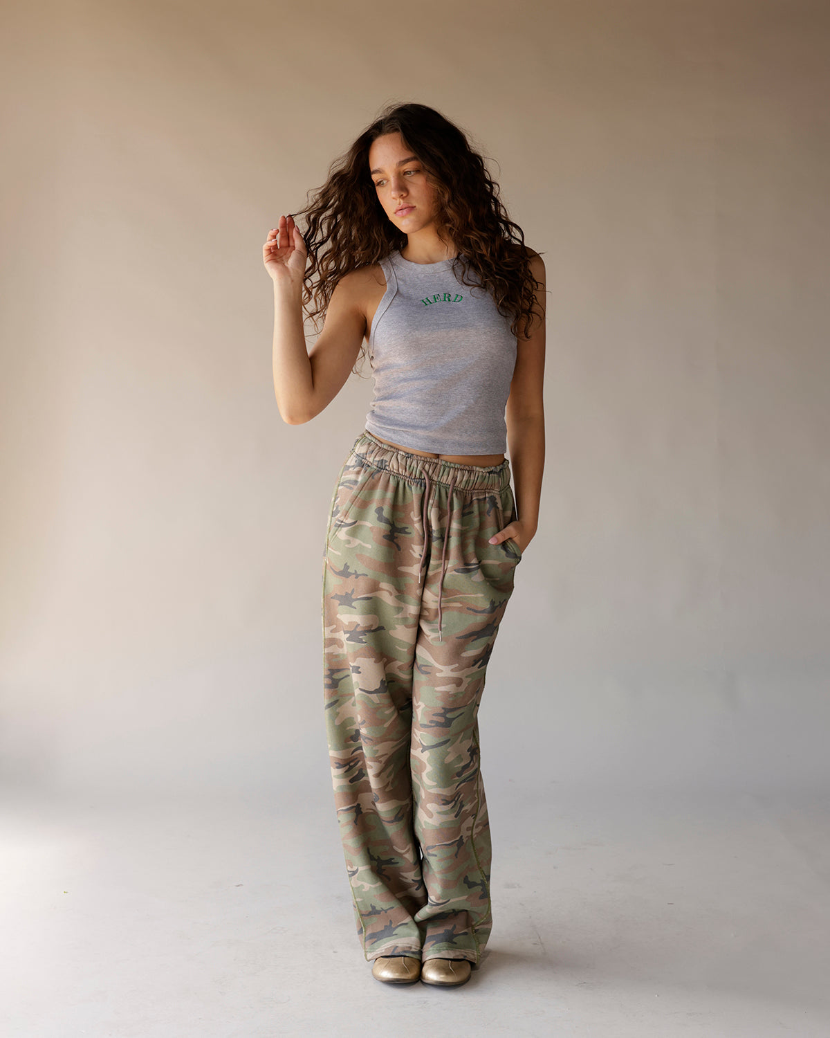 Gray sleeveless racerback crop tank top with green arched text graphic