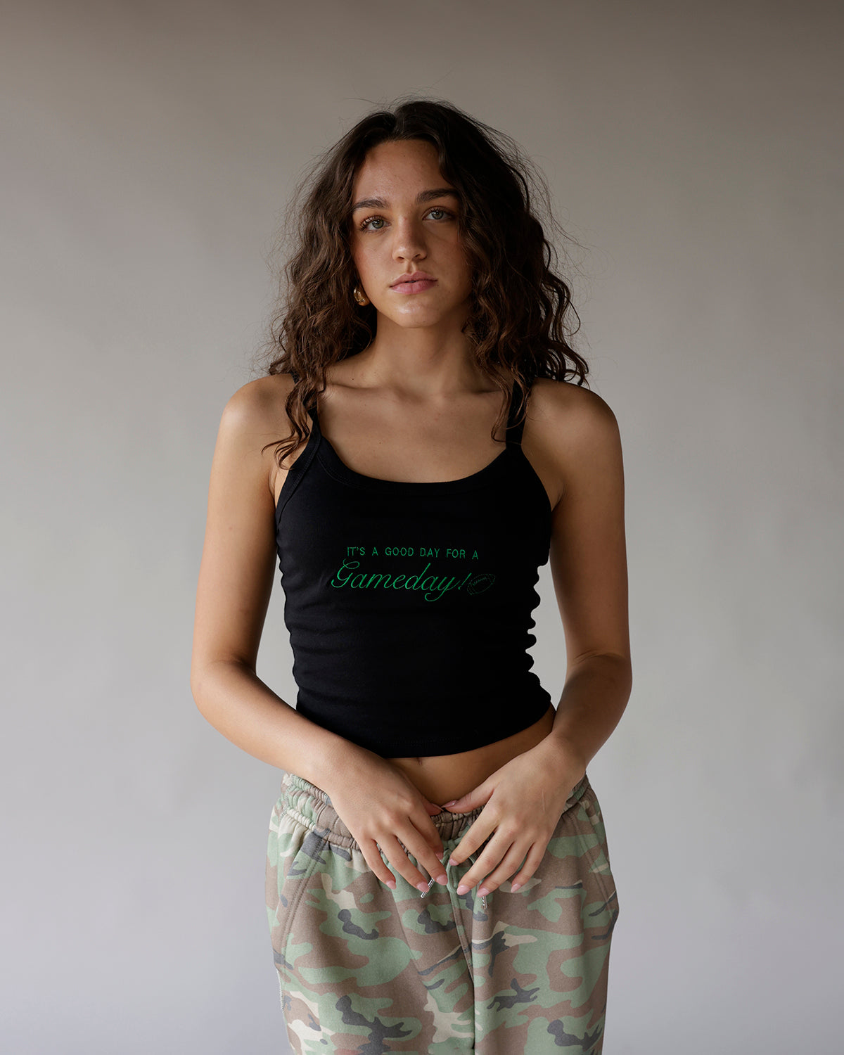 Black sleeveless crop tank top with green Gameday script graphic print
