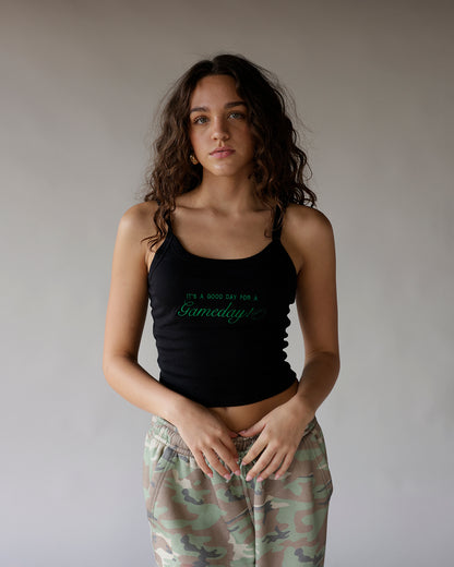 Black sleeveless crop tank top with green Gameday script graphic print