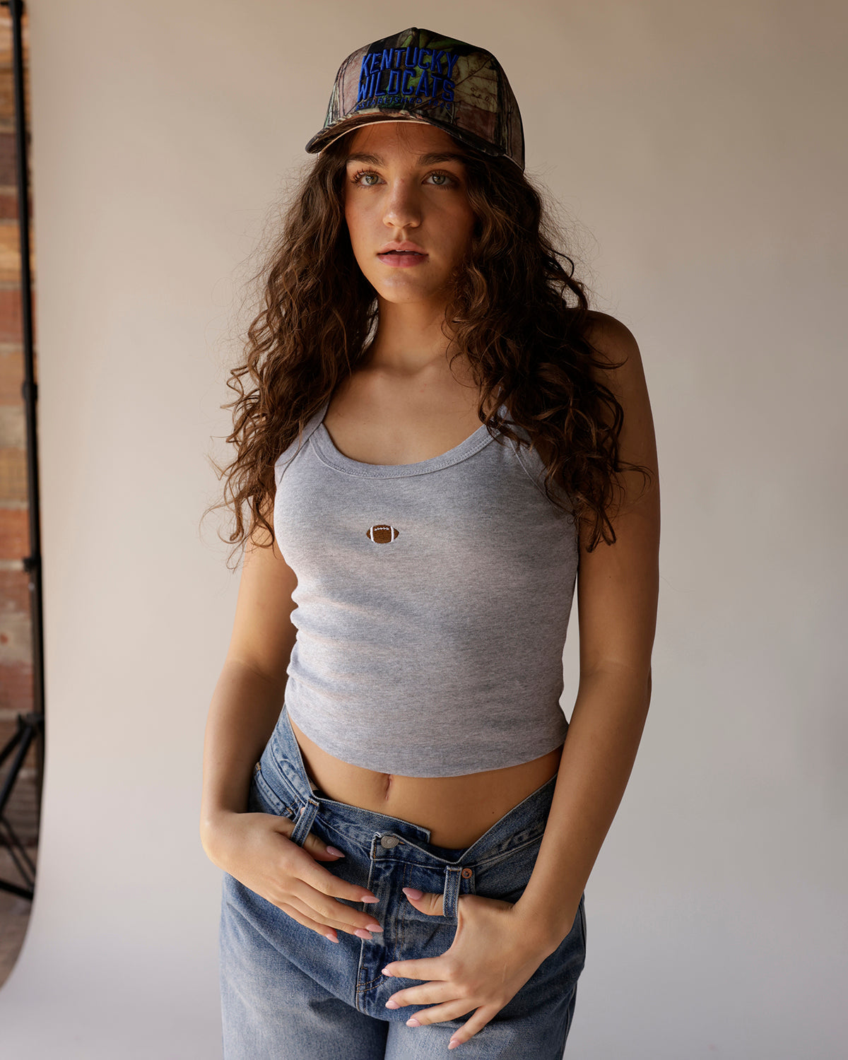 Gray sleeveless crop tank top with small football embroidery at chest center