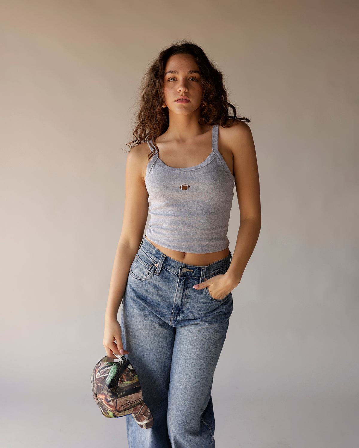 Gray cropped tank top with small football embroidery at center chest