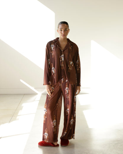 chocolate brown christmas pajama set with vintage nutcracker print, fine vertical stripes, long-sleeve button-down top and matching wide-leg pants.