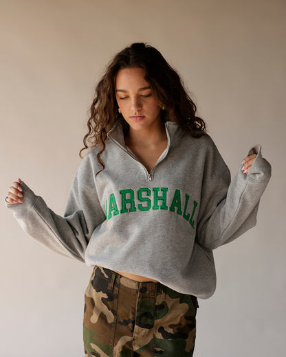 Gray Marshall quarter-zip cropped sweatshirt with green varsity lettering and camo pants