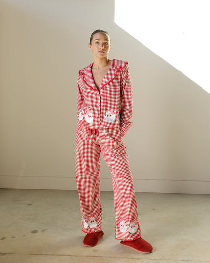 red and white gingham christmas pajama set featuring an oversized collar, vintage santa appliqués, button-front top and matching wide-leg pants.