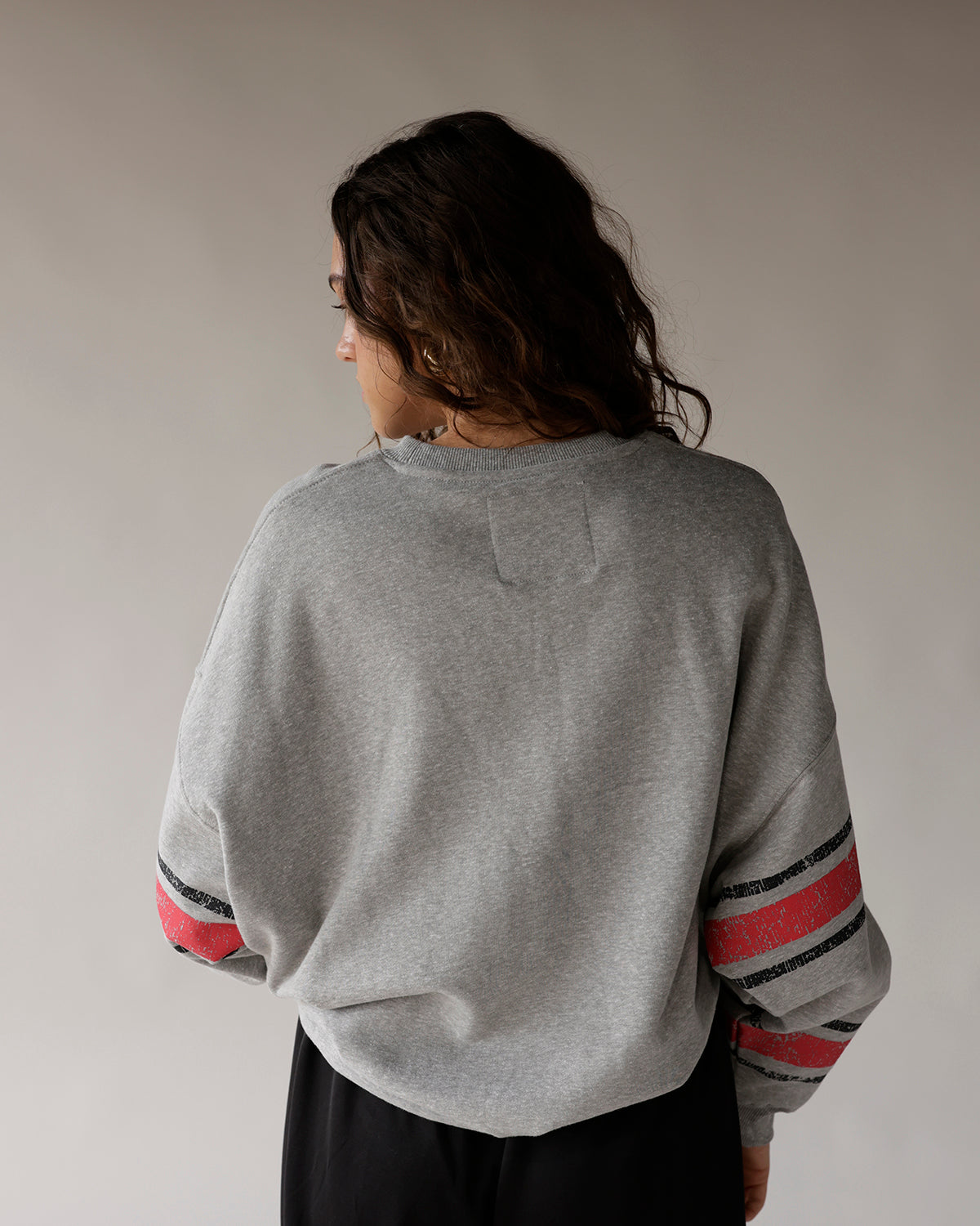 Gray Ohio State crewneck sweatshirt with red and black stripe sleeves, back view