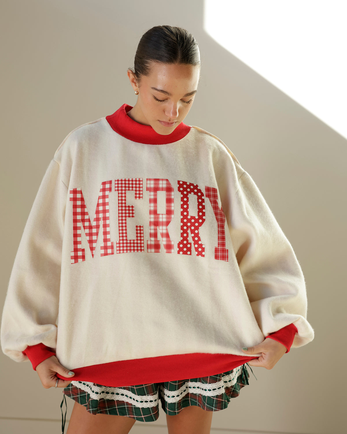reversible ivory and red christmas mockneck sweatshirt featuring mixed-pattern merry lettering on one side and bold vertical candy-cane stripes on the reverse.