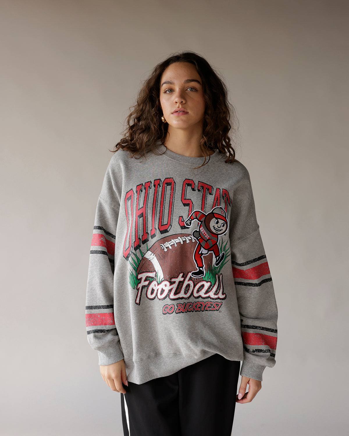 Gray Ohio State Football throwback crewneck sweatshirt with striped sleeves and Brutus mascot graphic