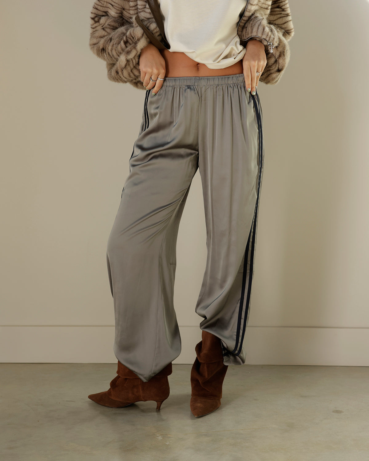 Loucia taupe-gray satin-look track pants featuring contrasting black double side stripes, an elastic waistband, side pockets and a relaxed wide-leg silhouette.