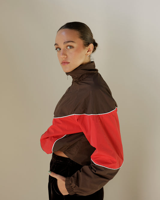 pretty garbage women's chocolate brown and red colorblock windbreaker jacket featuring a high collar, full zip front, contrast piping and elasticized cuffs.