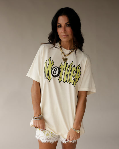 Cream oversized graphic tee with flaming MOTHER 8-ball logo in yellow and black