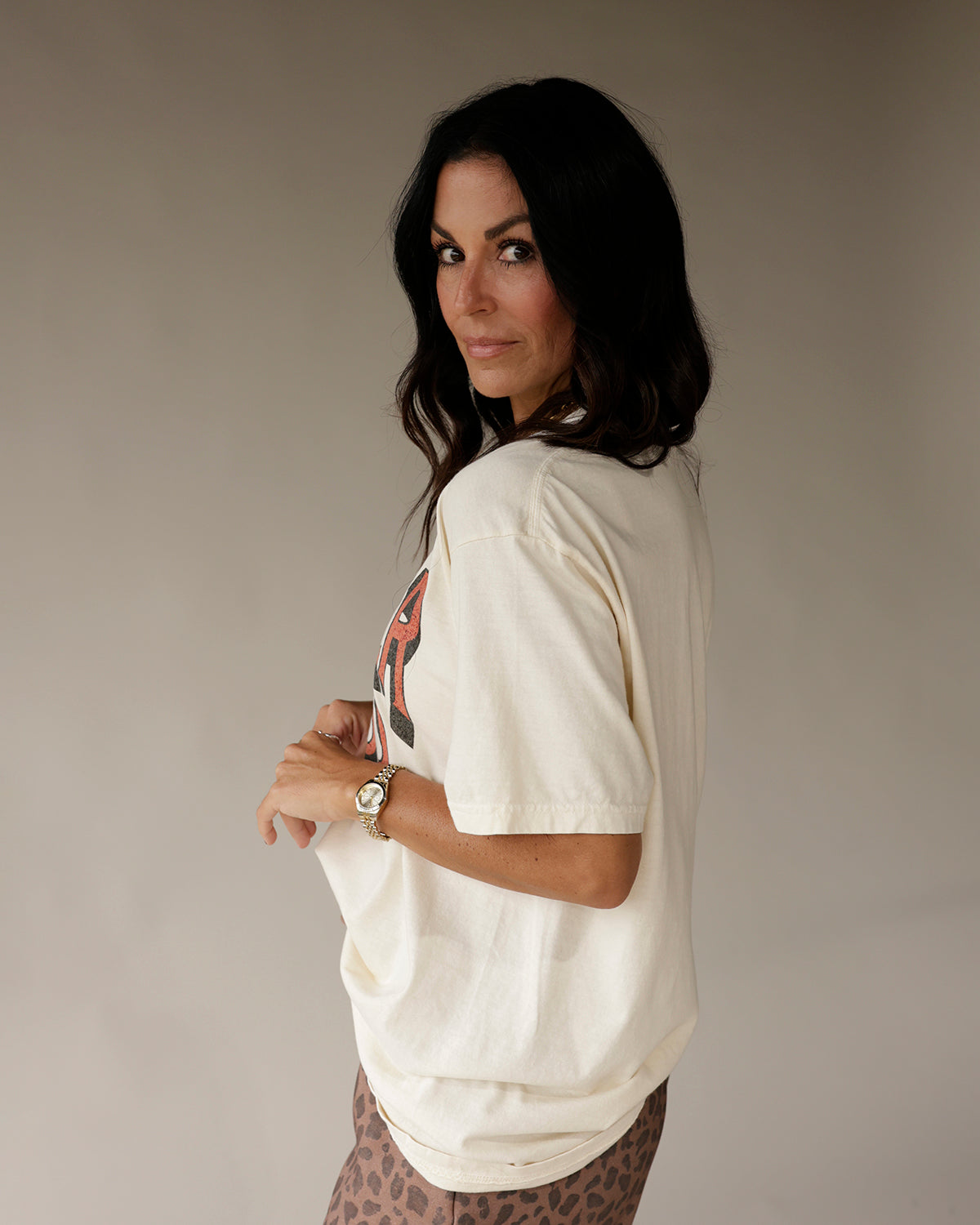 Cream oversized graphic tee with red print, worn with leopard print pants