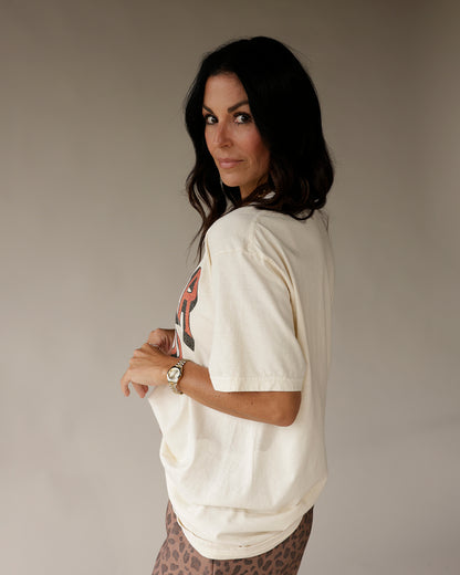 Cream oversized graphic tee with red print, worn with leopard print pants