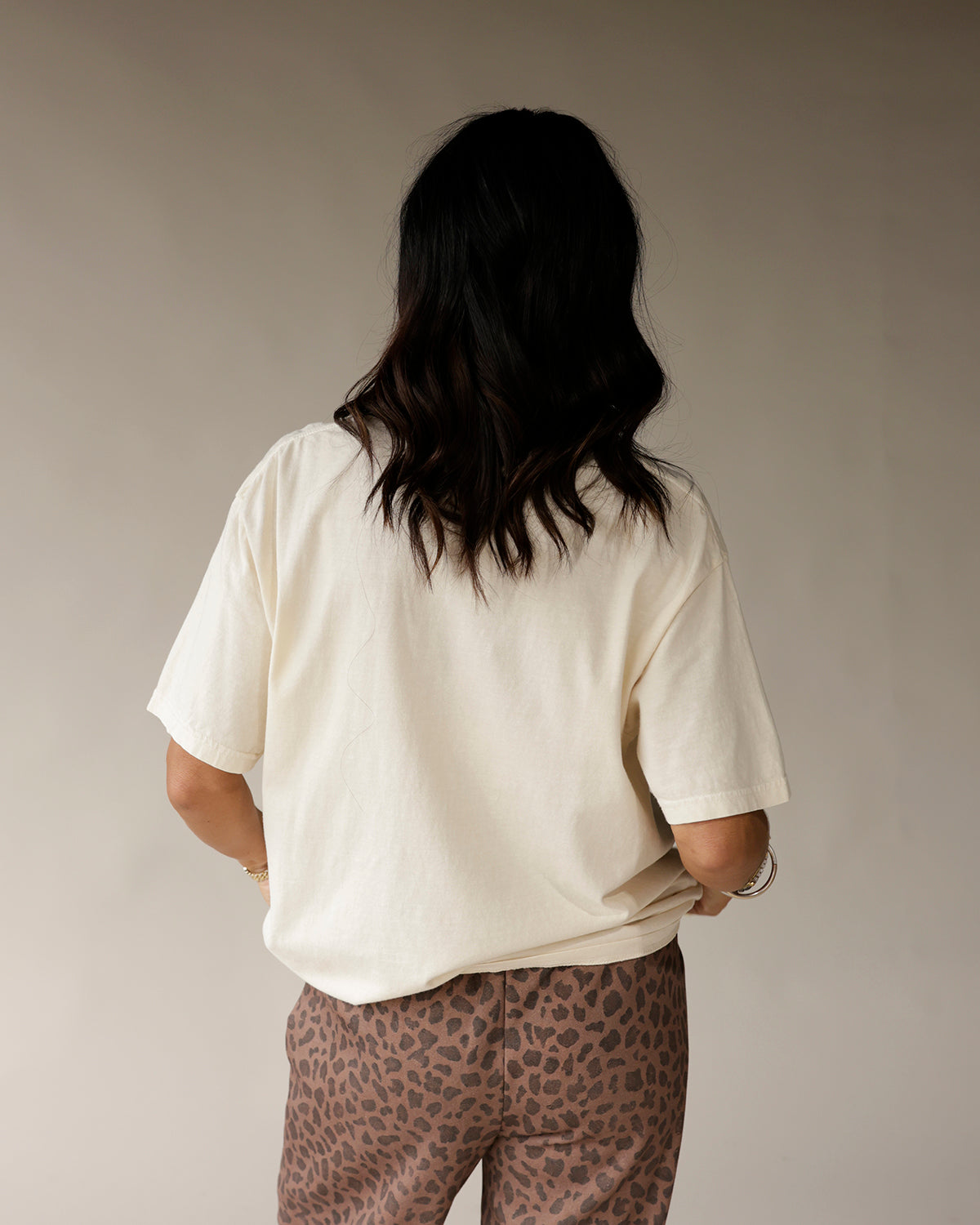 Oversized cream vintage graphic tee, back view, paired with leopard print pants.
