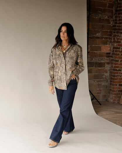 Women's oversized camo print button-up shacket with chest pockets, worn open