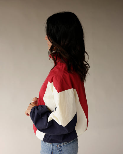 Retro colorblock windbreaker jacket in red, cream, and navy worn by model
