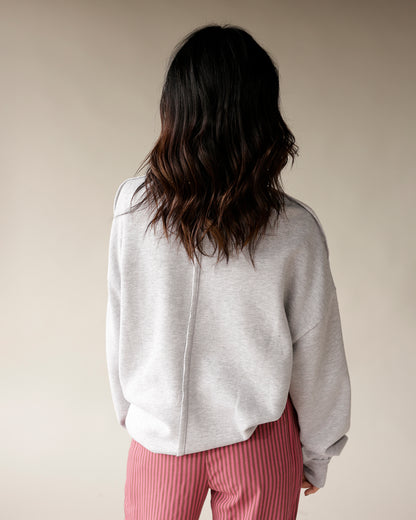 Women's oversized heather gray sweatshirt with center back seam, paired with pink striped pants