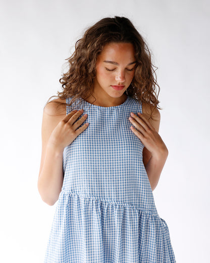 Sleeveless blue gingham tiered maxi dress with round neckline and drop waist