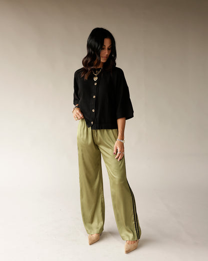 Black button-front cropped cardigan top with three-quarter sleeves on model