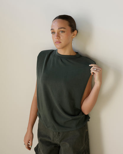 girl wearing forest green sleeveless Tshirt with pants, muscle tee, tank top 