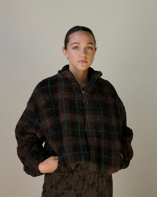 women's chocolate brown oversized sherpa jacket with forest green plaid detailing, plush textured fleece, high stand collar, front zipper and pockets.