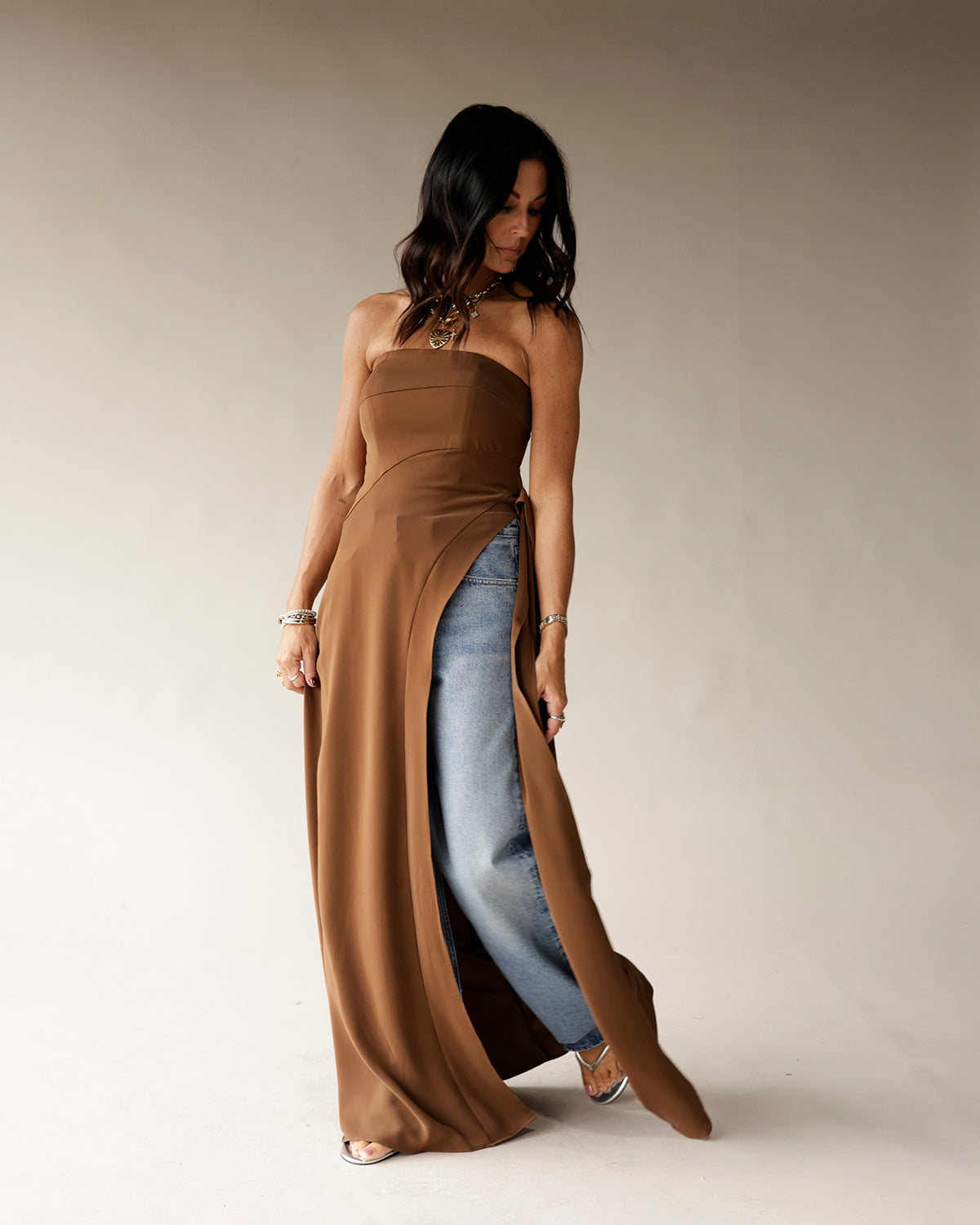 Camel strapless maxi tunic with high slit, worn over blue jeans with silver heels