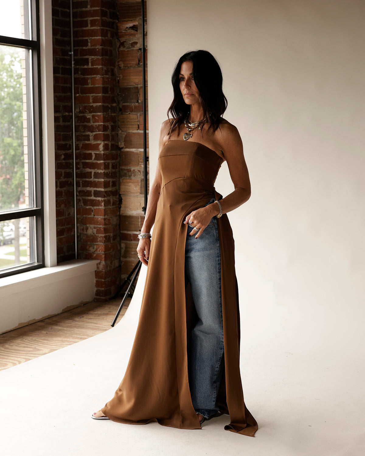 Camel strapless satin maxi tunic with dramatic side slits worn over jeans