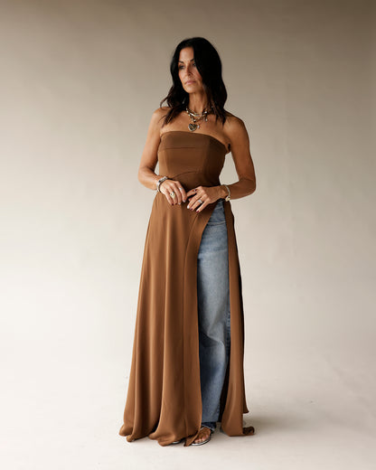 Brown strapless maxi tunic with high slit, styled over wide-leg jeans