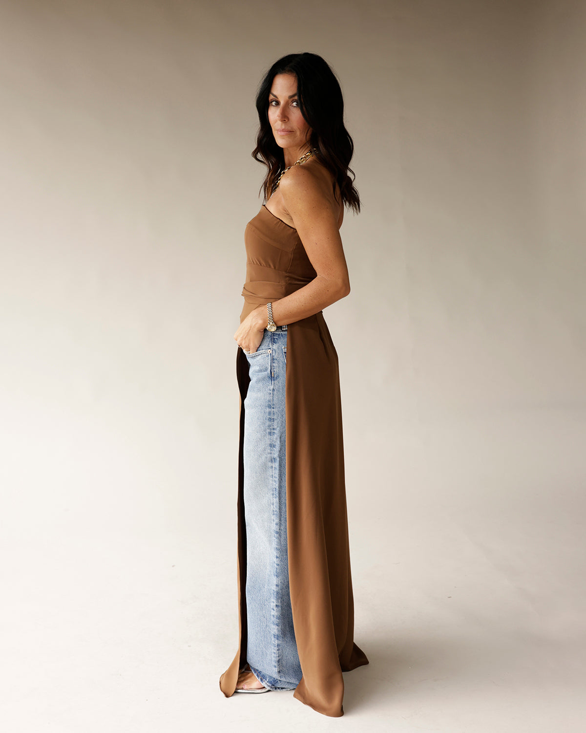 Brown sleeveless satin tunic with chain strap detail, styled over light wash jeans