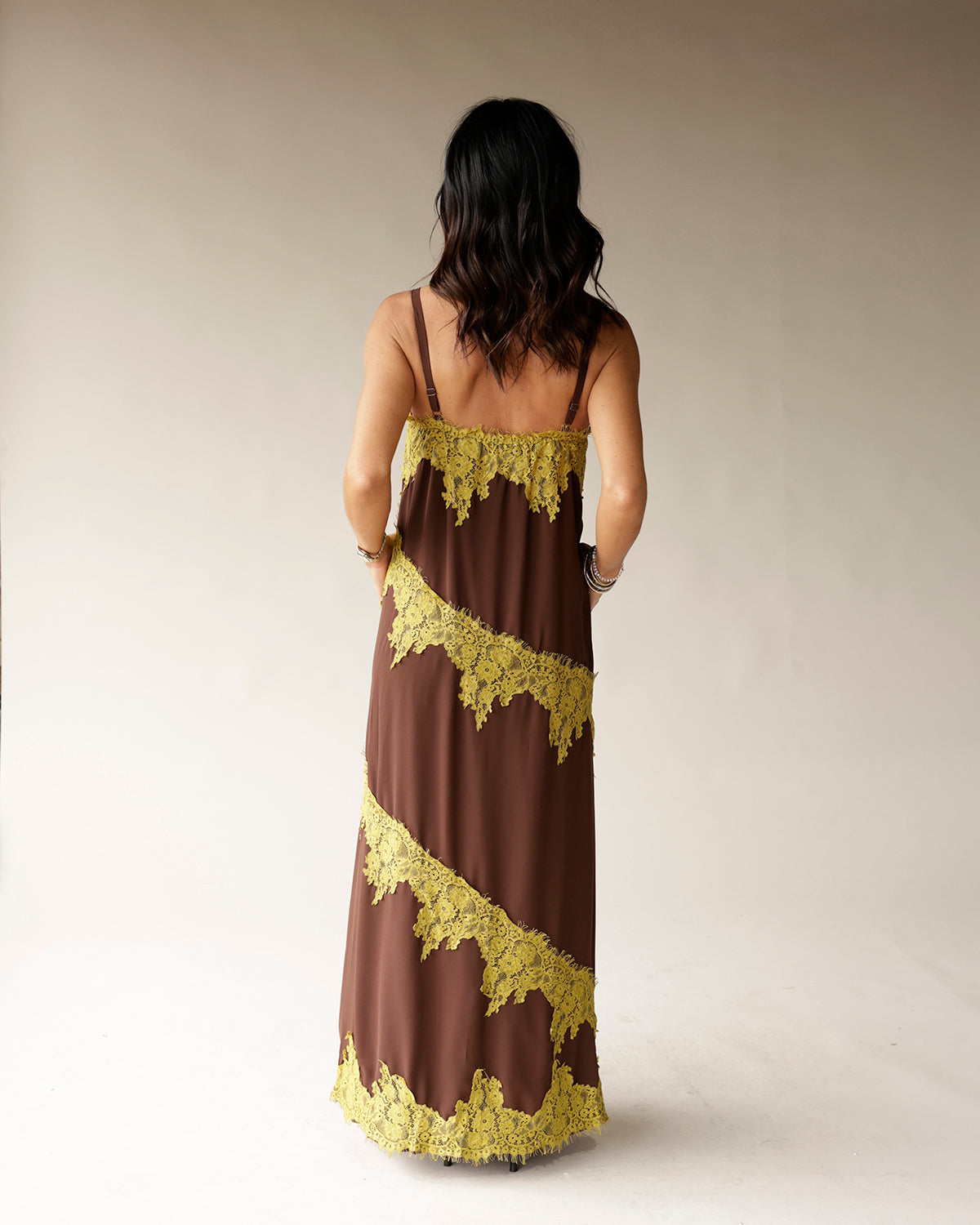 Brown maxi dress with diagonal yellow lace trim stripes and spaghetti straps
