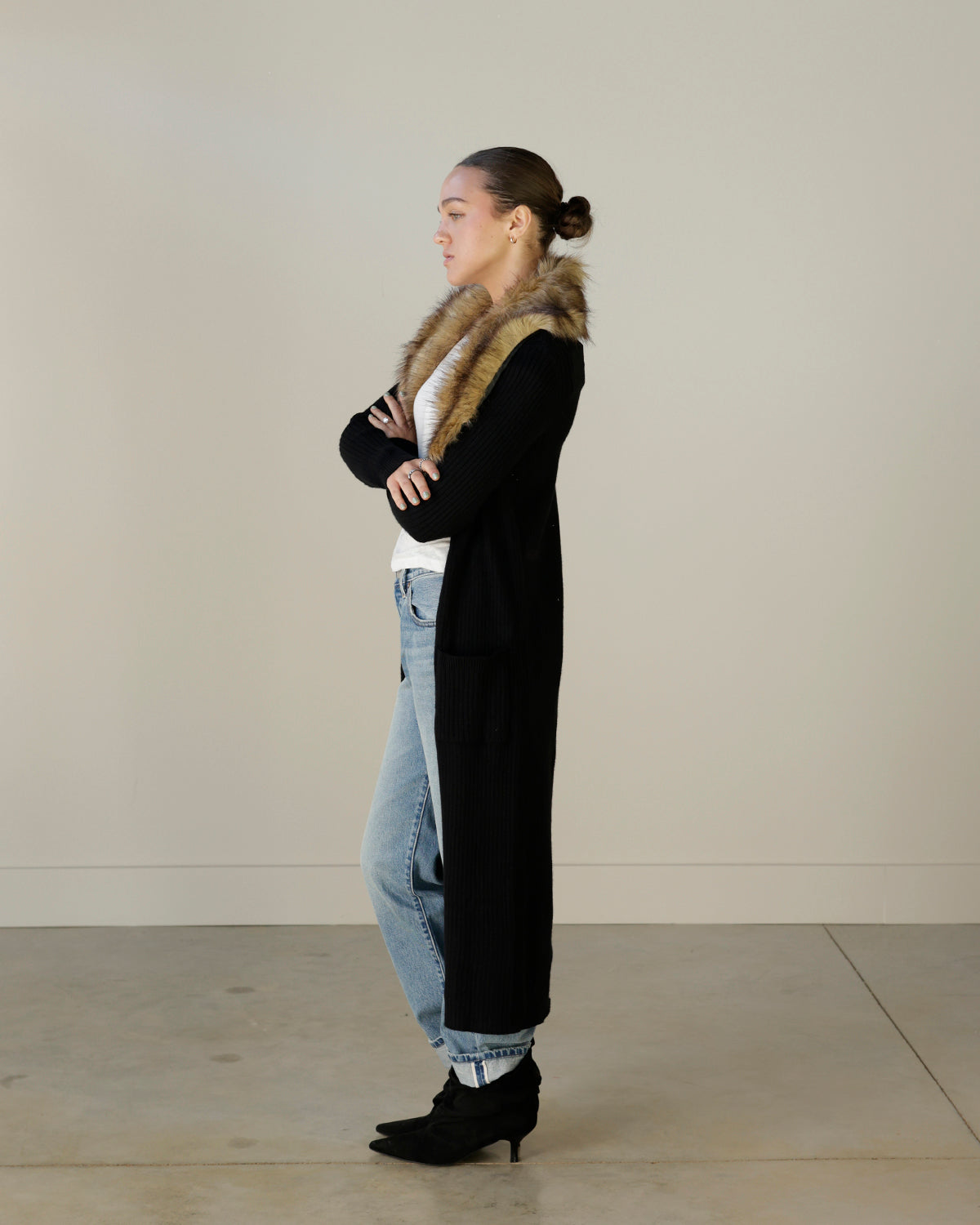 women's black ribbed knit maxi cardigan featuring a dramatic caramel brown faux fur collar, open front, long sleeves and front patch pockets.