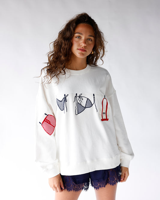white sweatshirt with embroidered bikini clothesline graphic 