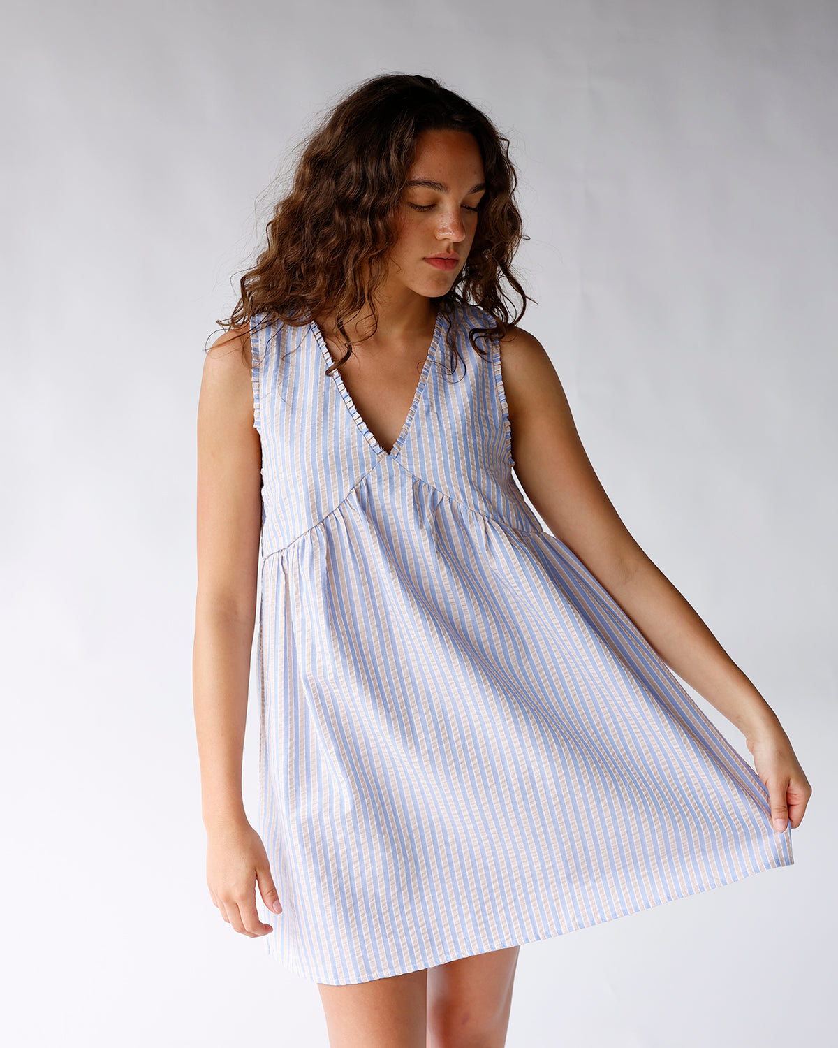 Sleeveless striped mini dress in blue and white with V-neckline and full skirt