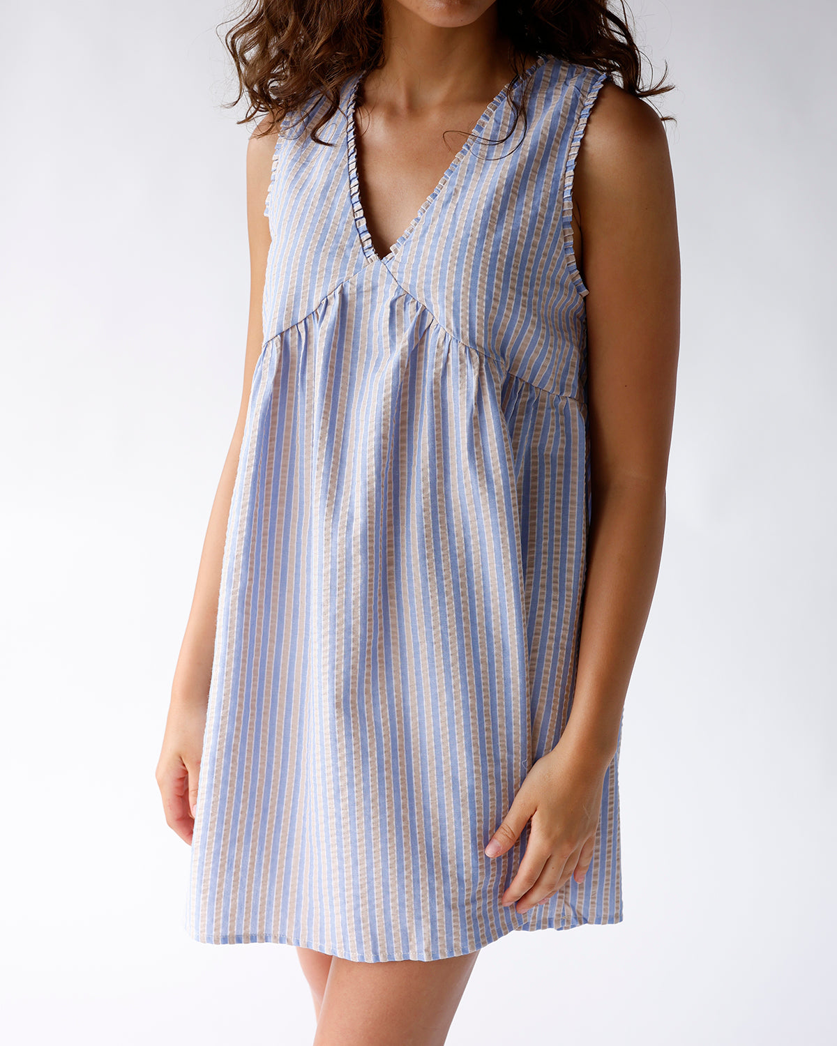 Blue and tan striped sleeveless mini dress with V-neck and ruffle trim