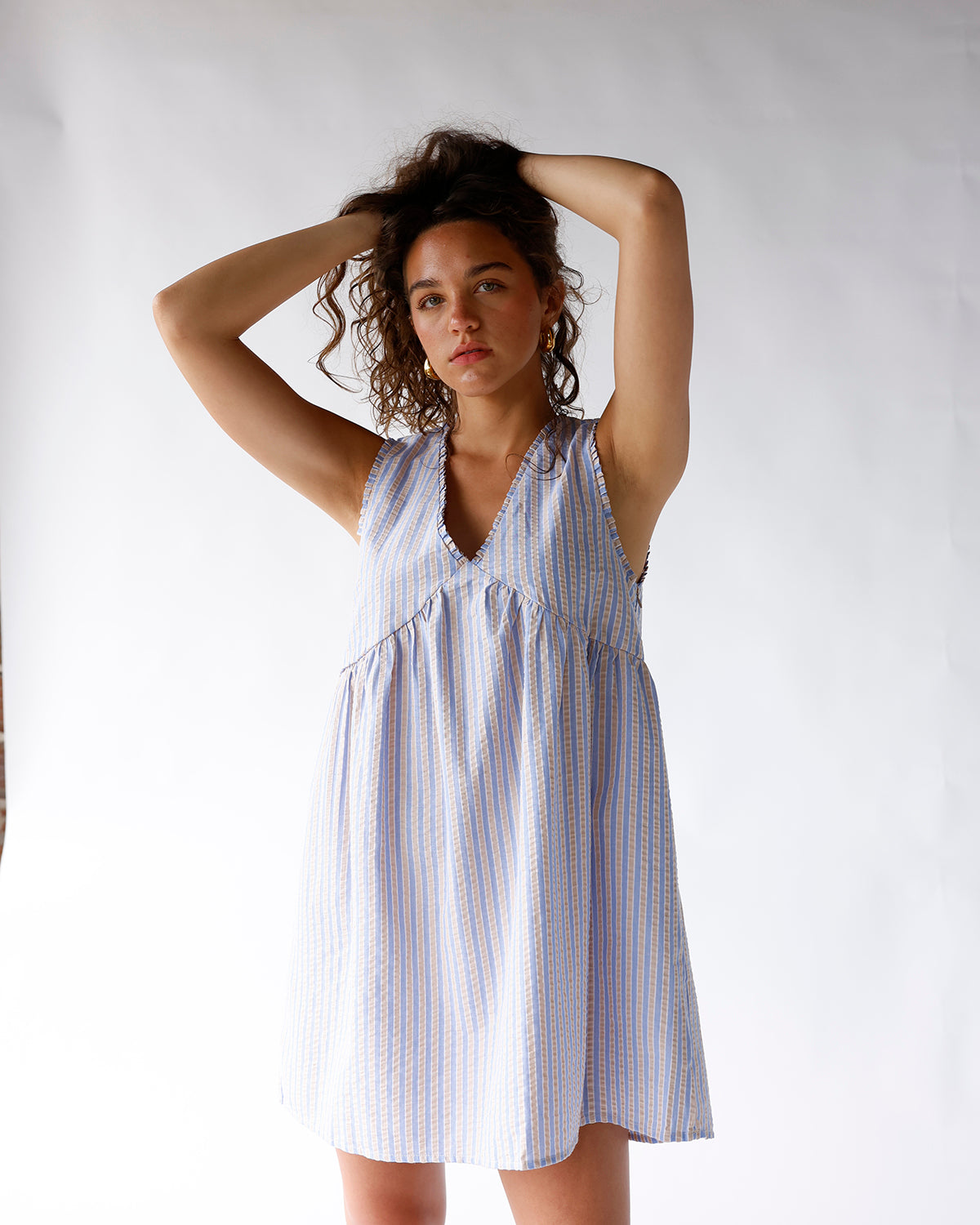 Blue and white striped sleeveless mini dress with V-neck and tiered skirt