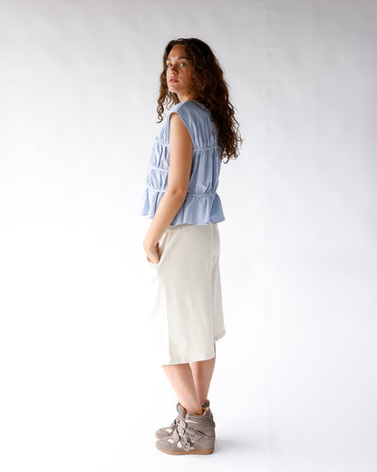 Light blue sleeveless tiered ruffle top with gathered elastic banding details