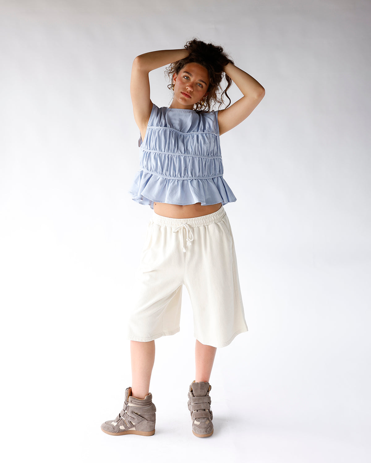 Light blue sleeveless smocked ruffle crop top with tiered gathered detailing