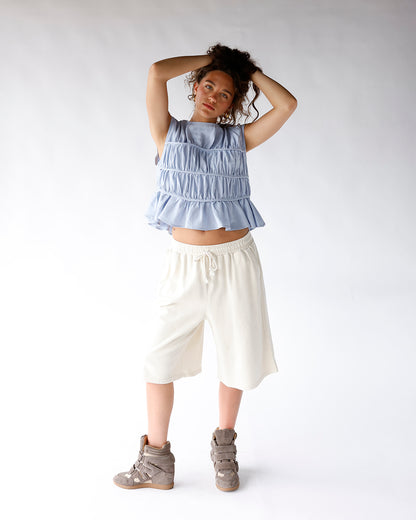 Light blue sleeveless smocked ruffle crop top with tiered gathered detailing