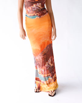 Inspired by the coastal beauty of Italy and Greece, this sunset-hued mesh maxi skirt features a flowing silhouette and dreamy Mediterranean print for an effortlessly elegant look.